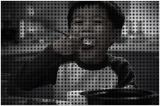 한 아이가 숟가락으로 밥을 퍼서 한입 가득 먹고있는 모습