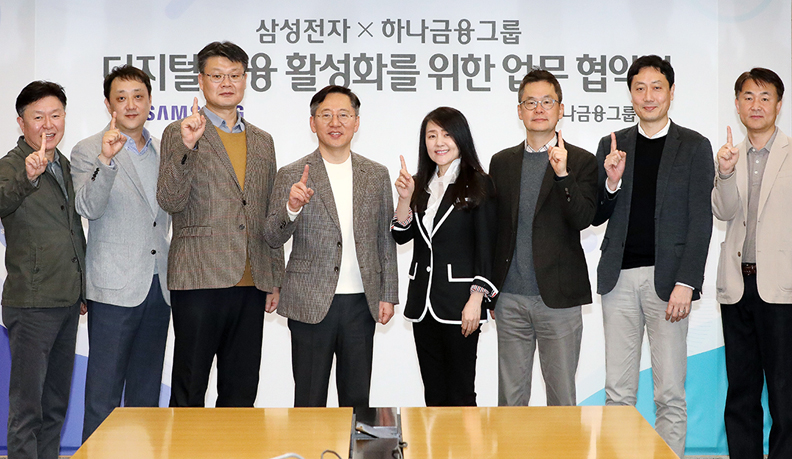 하나금융그룹 임직원과 삼성전자 임직원이 디지털 금융 활성화를 위한 업무 협의식에서 손가락 하나를 들고 홍보하는 이미지